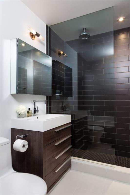 Ruskeat modernit kylpyhuoneen metrolaatat tummanruskeassa suihkussa lasiseinässä valkoiset kylpyhuonekalusteet