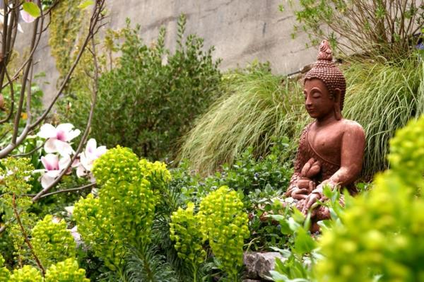 Juuri istuta puutarhaan Buddha -hahmoja