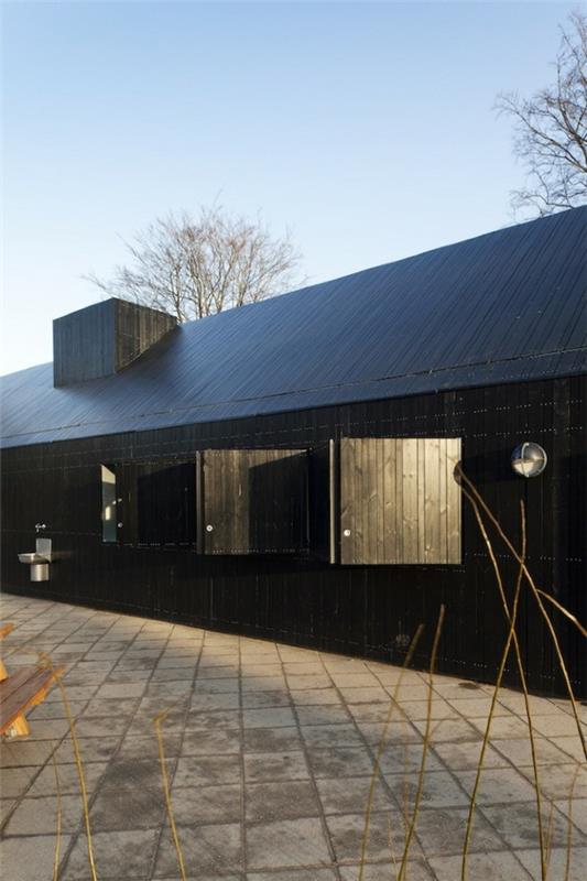 Suunnittelija -talo, jossa on peilattu julkisivu, musta elementtitalo