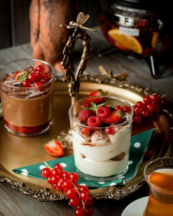 Mansikka tiramisu lasissa Vadelmia ja puolitettuja mansikoita