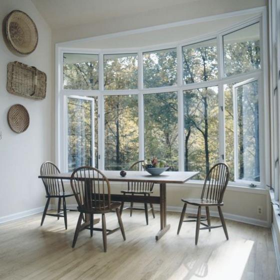 Erkkeri ruokasalissa maalaismainen tyyli pieni seinäkoriste muut huonekalut, joista puuttuu luonnollinen näkymä takapihalle