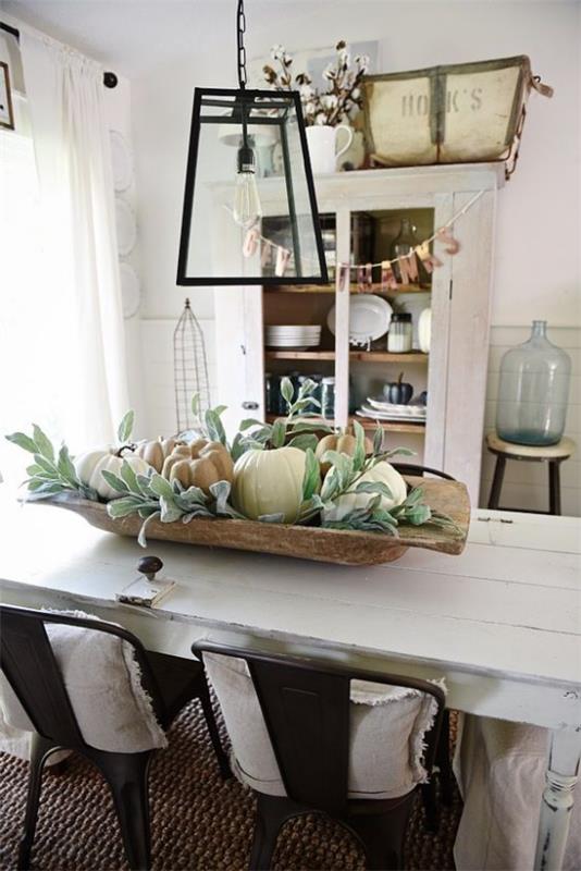 Koristele ruokasalin syksyinen ruokapöytä koristele iso puinen kulho ruokapöydän keskellä täynnä kurpitsia ja vihreitä lehtiä maalaismainen tyyli