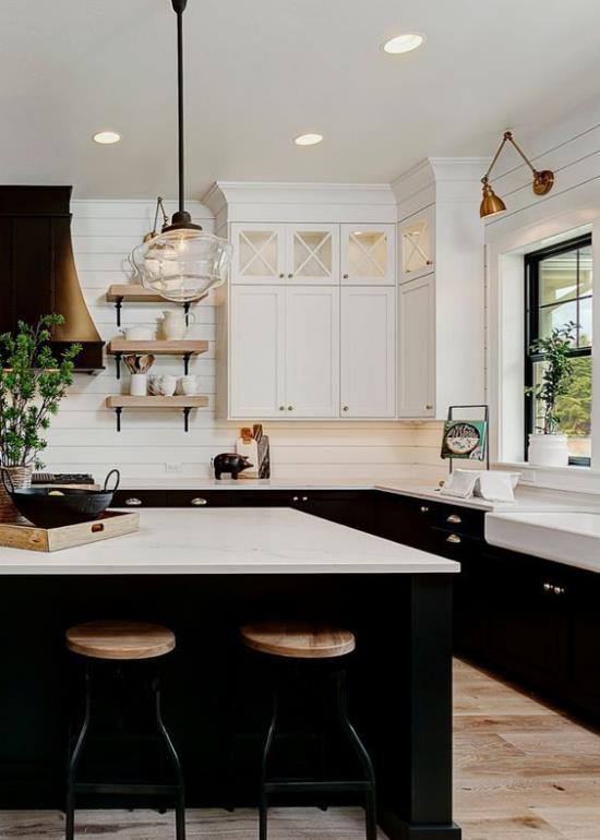 Väriparit valkoiset keittiökaapit valkoisen keittiösaaren yläpuolella mustat pohjakaapit vaalea puu erittäin tyylikäs sisustus