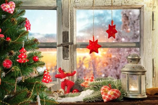 Ikkunoiden koristelu kankaasta valmistetuille punaisille joulukoristeille