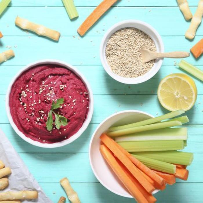 Food Trends 2020 -raaka -vihannekset syövät ohuita tikkuja porkkanaa ja selleriä kastikkeilla