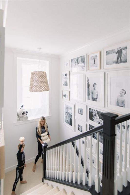 Valoseinä portaikossa monia kuvia valkoisissa kehyksissä äiti poika portaissa