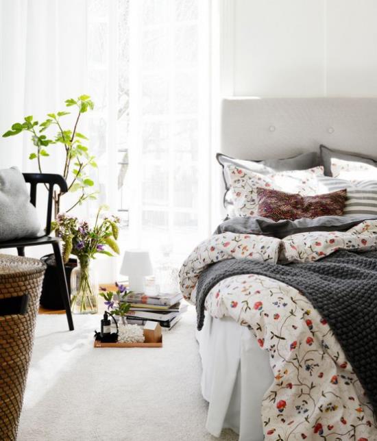 Kevään sisustusideoita makuuhuoneeseen kukkakuvioiset vuodevaatteet pehmeät tekstiilimaljakko kukilla vihreä ruukkukasvi pehmeä matto