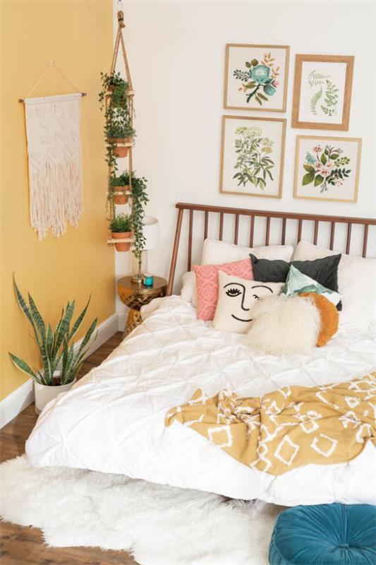 Kevään sisustusideoita makuuhuoneen makrameelle seinällä maalaismainen pussilakana, jossa reunat värikkäät kuviolliset tyynyt kodikkuutta huoneideoissa