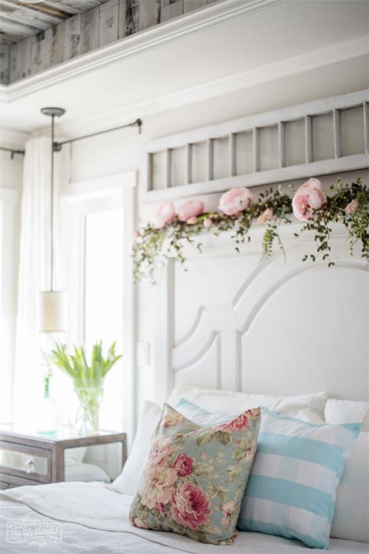 Kevään sisustusideoita makuuhuoneeseen Ruusut tyynyllä kukkakuviona sängyn päätyyn koruina