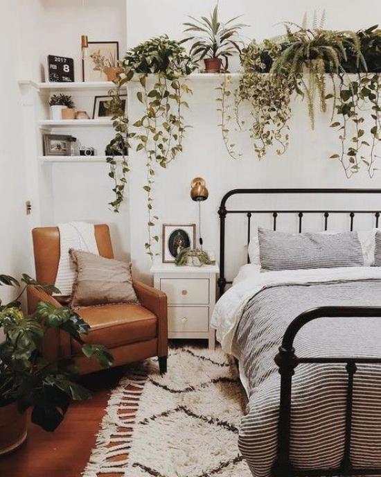 Makuuhuoneen kevätkoriste -ideoita vihertävät monet vihreät ruukkukasvit sängyn yläpuolella olevalla hyllyllä