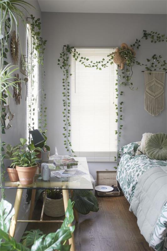 Kevään sisustusideoita makuuhuoneeseen vihertävät monet vihreät ruukkukasvit pöydällä ja päiväpeite, jossa on vihreä kuvio