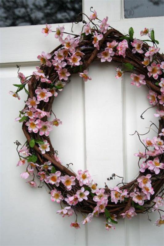 Kevään koristelu kirsikankukkien oviseppeleellä kutsuva ja tyylikäs samaan aikaan