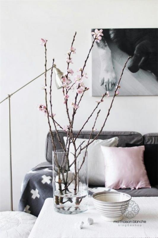 Kevään koristelu kirsikankukalla muutamia kirsikka oksia olohuoneen lasipöydässä sohvapöydällä