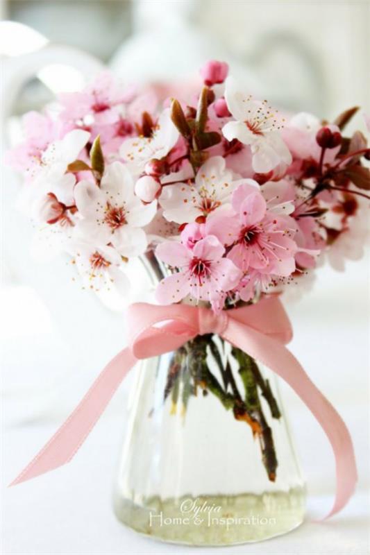 Kevään koristelu kirsikankukilla vaaleanpunaisilla kukilla vaaleanpunaisella nauhalla