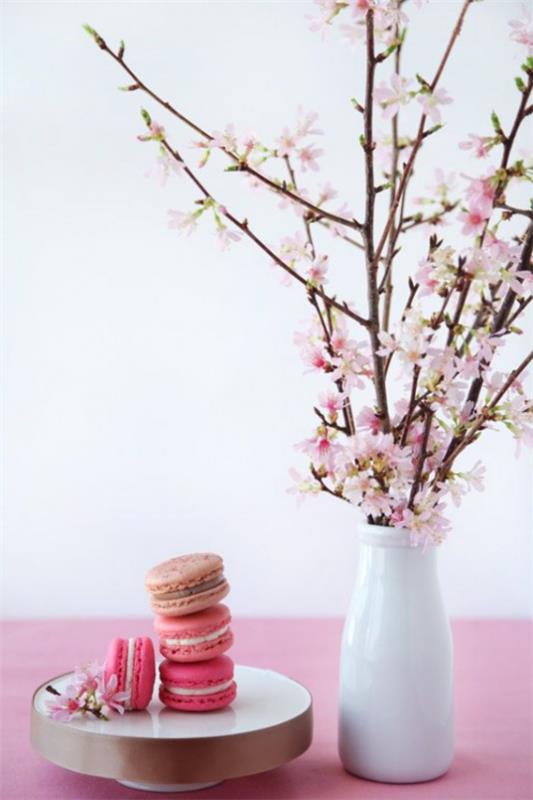Kevään koristelu kirsikankukilla vaaleanpunainen pöytäliina valkoinen posliini maljakko vaaleanpunainen macaroons