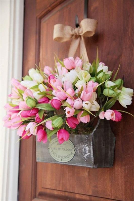 Kevään seppeleet kauniista vaaleanpunaisista tulppaaneista ulko -oven vanhassa puulaatikossa