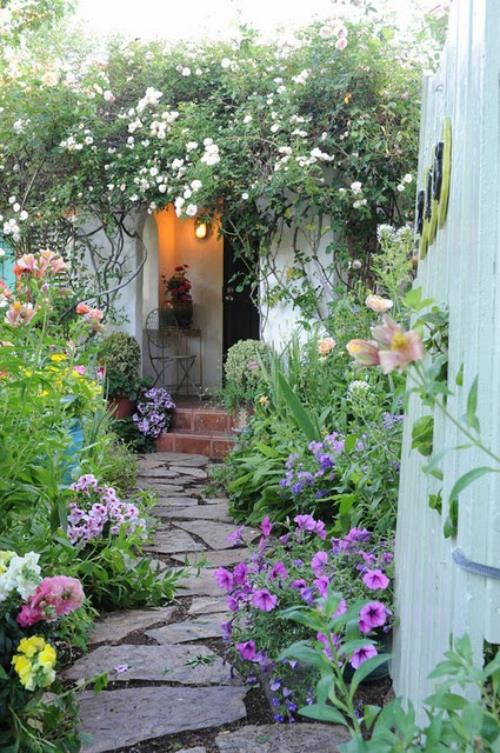 Kivestä valmistetut puutarhapolut, joissa on paalukivet ja auringonkukan ympäröimänä, johtavat suoraan talon sisäänkäynnille