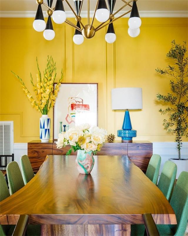 Sisustussuunnittelun salaisuudet paljastavat ruokasalin lämpimässä, aurinkoisessa keltaisessa, keltaisessa seinässä, vaaleanvihreät tuolit, keltaiset gladiolit suuressa maljakossa