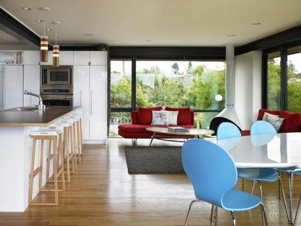 Olohuone ja keittiö yhdistettynä yhteen huoneeseen nojatuoli sininen ruokapöytä