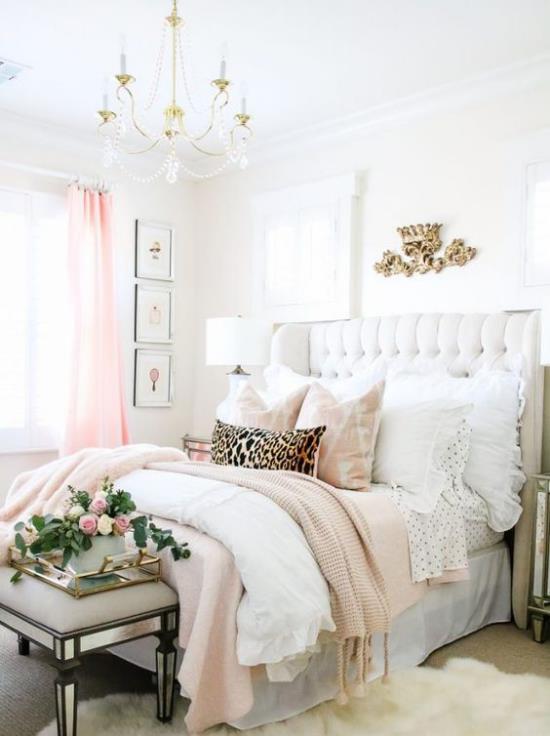 Lumoavat makuuhuoneet kauniisti suunnitellut pehmeät peitot lakanat muutamia tuoreita ruusuja vihreitä