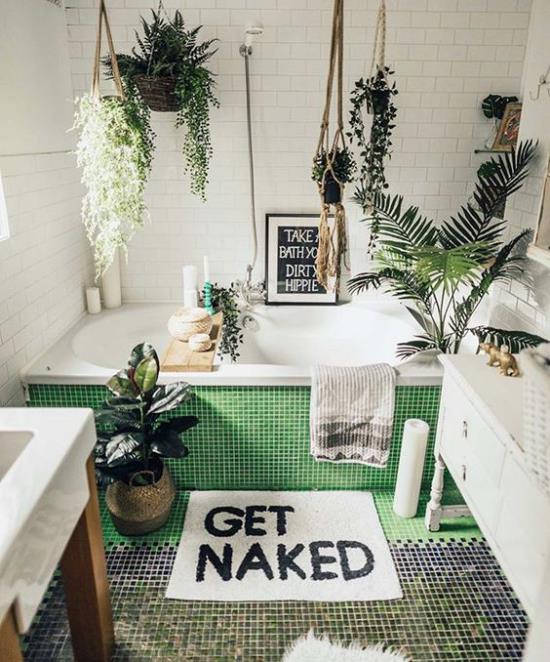 Vihreä kylpyhuoneessa kaakeloitu kylpyamme maalaismaiseen tyyliin monet vihreät kasvit riippuvat kasvit