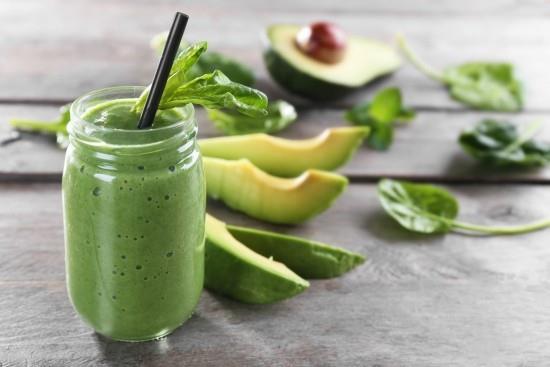 Vihreä smoothie lasissa avokado -pinaatinlehtiä