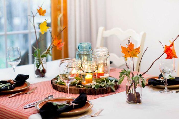 Tee syksyn koristeita värikkäillä lehdillä ja kynttilöillä ruokapöydän koristamiseksi