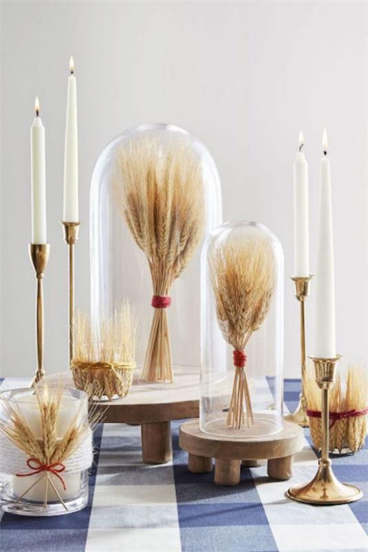 Syksyn koristelu vehnällä kaunis pöytäkoriste Vehnäpaketit lasin alla tyylikkäät kynttilänjalat valkoiset kynttilät
