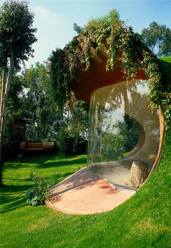 Hobbit Housen orgaaninen arkkitehtuuri lasiseinä saumaton siirtyminen sisä- ja ulkotiloihin