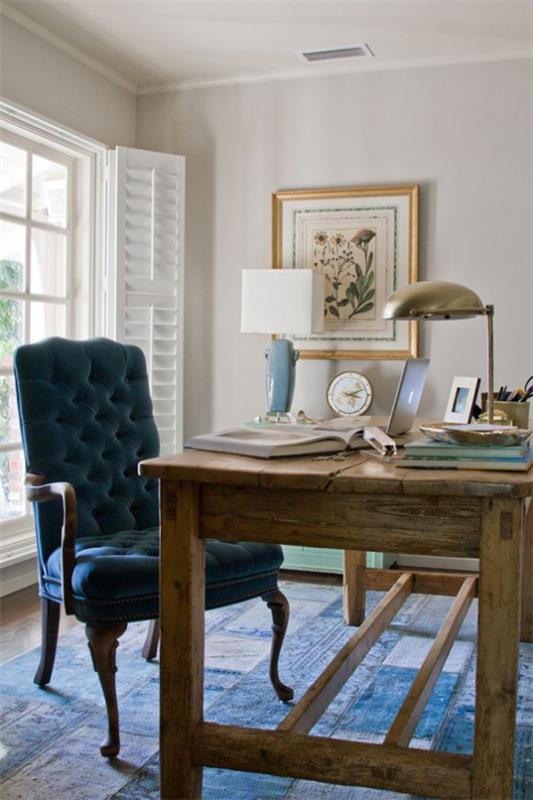Maalaistyylinen kotitoimisto massiivipuinen pöytä tummansininen nojatuoli sininen mattovalaisimet seinämaalaus tyylikäs huonesuunnittelu