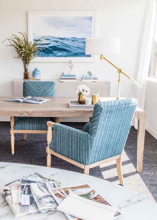 Kotitoimisto merenkulku pehmeät siniset sävyt seinämaalaus nojatuoli paljon luonnonpuuta ruohoa maljakko valkoisessa pöytävalaisimessa