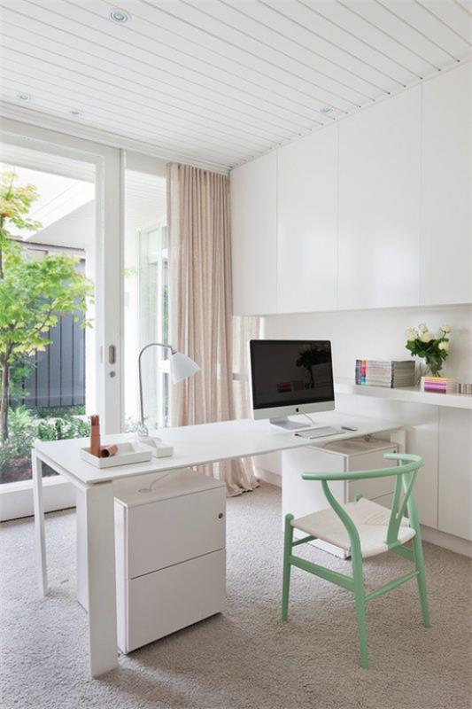 Kotitoimisto neutraaleissa väreissä tyylikäs pöytä -PC -tuoli pastellinvihreässä pöytävalaisimessa näyttää ulkopuolelta