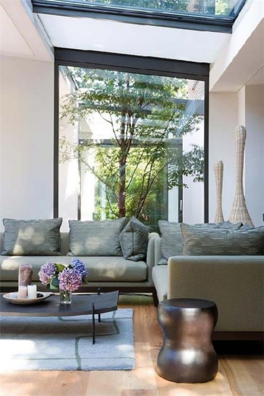 Tyylikäs sisäpihan minimalismi japanilaistyylisellä sohvapöydällä kukkamaljakolla taustalla pieni puutarha sisätiloissa ja ulkona harmoniassa
