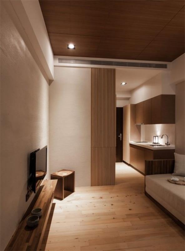 Japanilaiset olohuoneen bambu -liukuovet erottavat keittiön oleskelutilasta, jossa on paljon puisia vaaleita seiniä