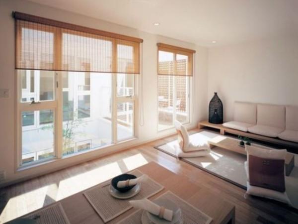 Japanilainen olohuone leveät ikkunat läpinäkyvät rullaverhot lattiatason huonekalut kaunis moderni sisustus