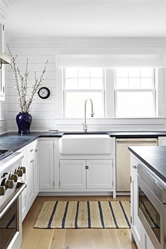Keittiösuunnitteluideoita valkoinen tilava keittiö paljon luonnonvaloa tummansininen maljakko matto