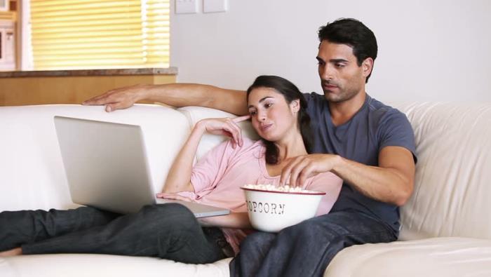 Ei pitkäaikaista suhdetta horoskooppi nuori rakastunut pari tasapainoinen sohvalla kotona kannettava tietokone tyytyväinen