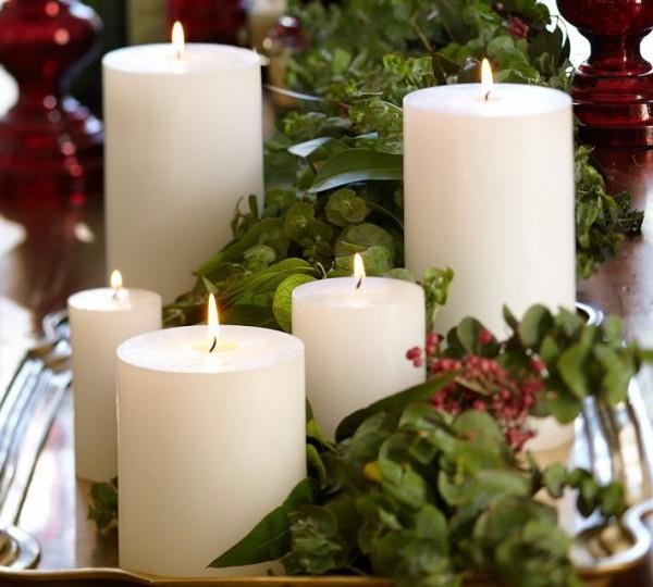 Kynttilät koristavat vihreitä joulukoristeita