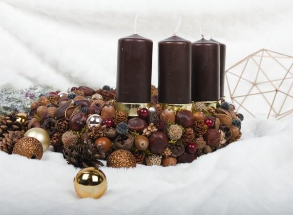 Kynttilät koristavat lumen ja pähkinöiden joulukoristeita