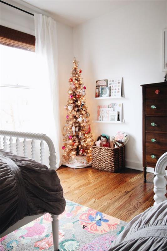 Koristele lastenhuone jouluksi, pieni koristeltu joulukuusi huoneen nurkassa
