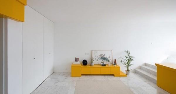 Pieni huoneisto, jossa on minimalistiset huonekalut, senkki ja raikasta ilmaa