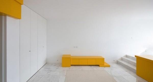 Pieni huoneisto minimalistinen huonekonsepti muutamia huonekaluja keltaisia ​​aksentteja