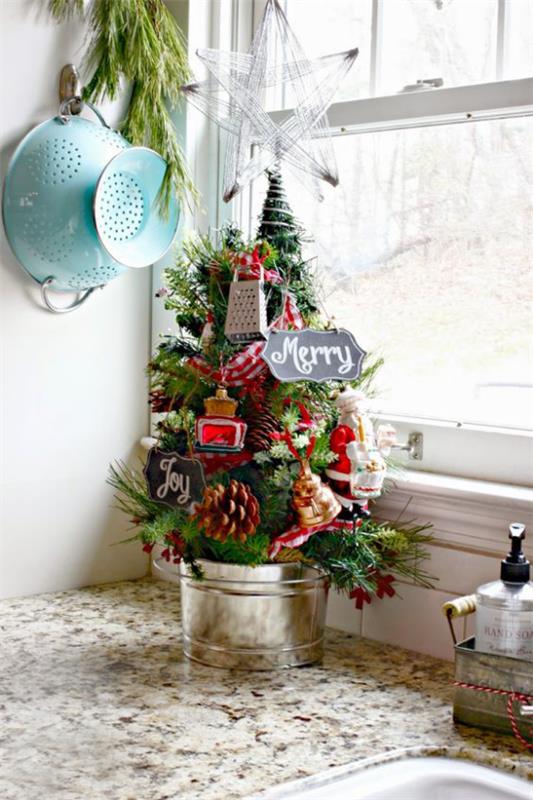 Pieni joulukuusi koristele näyttää pieniä keittiövälineitä puussa keittiön työtason nurkassa