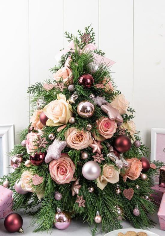 Pieni joulukuusi koristaa koristeita, jotka on koristeltu koruilla ja ruusuilla silmiin