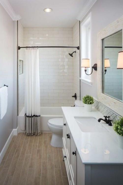 Pieni kylpyhuone valkoiset laatat iso seinäpeili seinävalaisin optinen harha