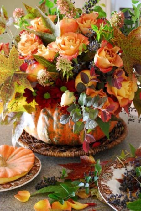 Kurpitsa maljakko monien värikkäiden kukkien pöydän koristeluun syksyllä