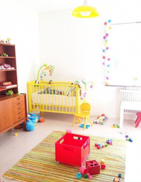 Sekalainen vauvan huone paljon leluja maton seppeleitä ikkunan keltaisessa sängyssä