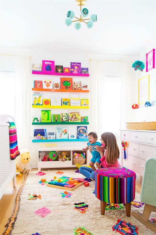 Värikäs vauvahuone. Pehmeä matto. Hylly. Värikkäitä kirjoja. Lelut. Värikäs jakkara