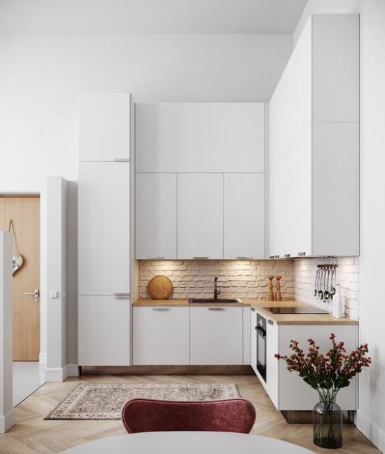 L-keittiön pieni nurkka-tiiliseinä hyvin valaistu erittäin tyylikäs valkoinen keittiö osa avointa asumista