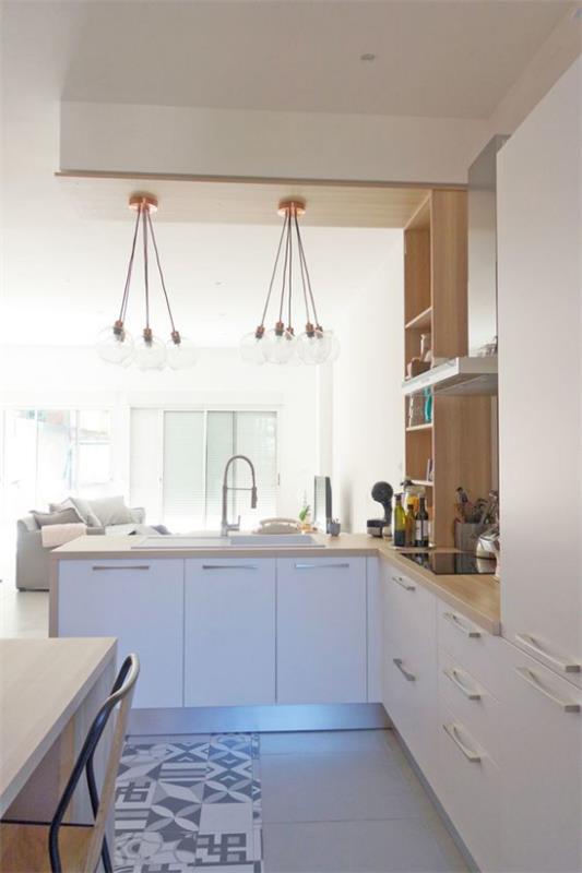 L-keittiö kaunis muotoilu integroituna moderniin olohuoneeseen valkoiset kaapit vaaleat puiset pöytävalaisimet